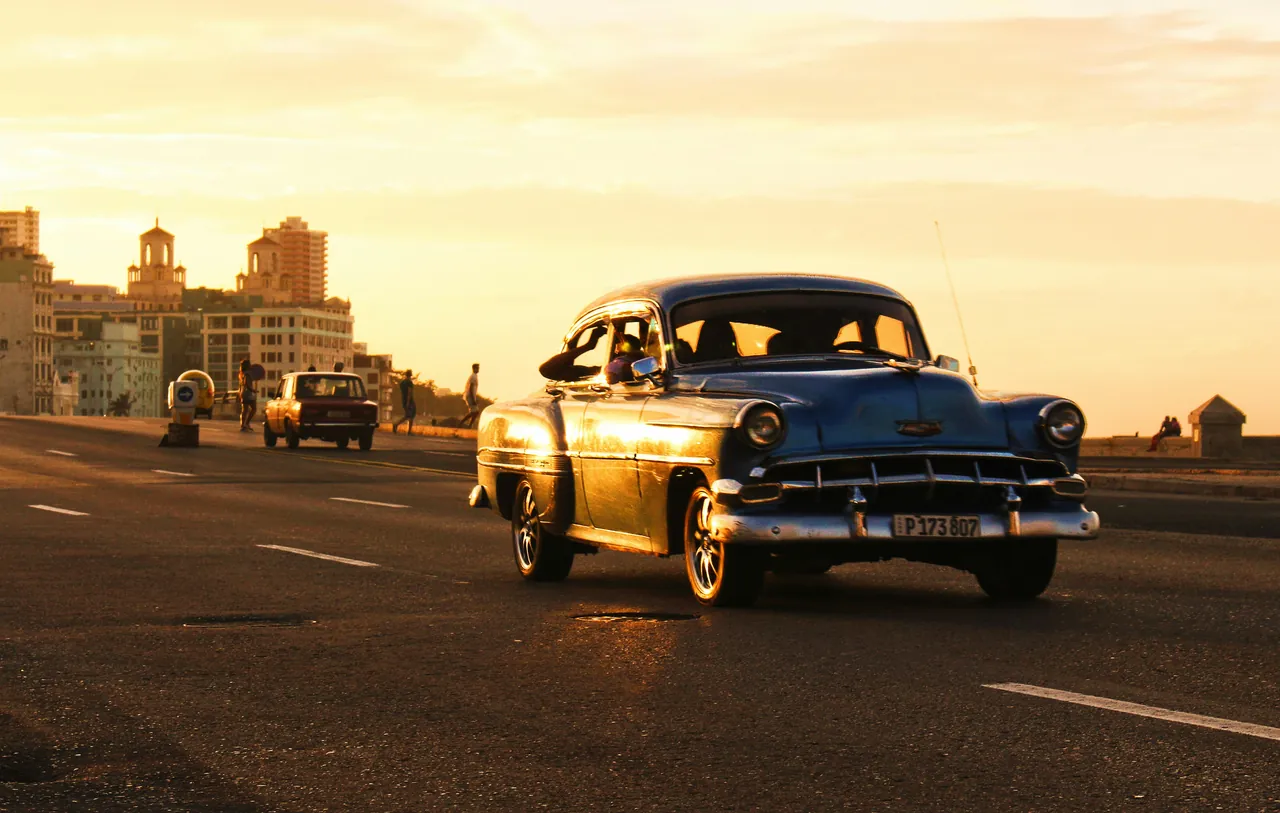 Old American car riding along the Malecon. Photo by Jason Higuita.