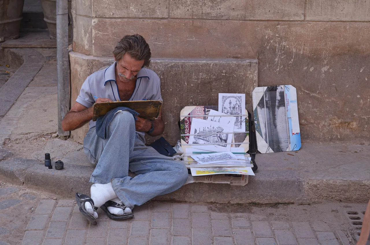 Street artist sitting in a street corner. Photo by Nico Castez.