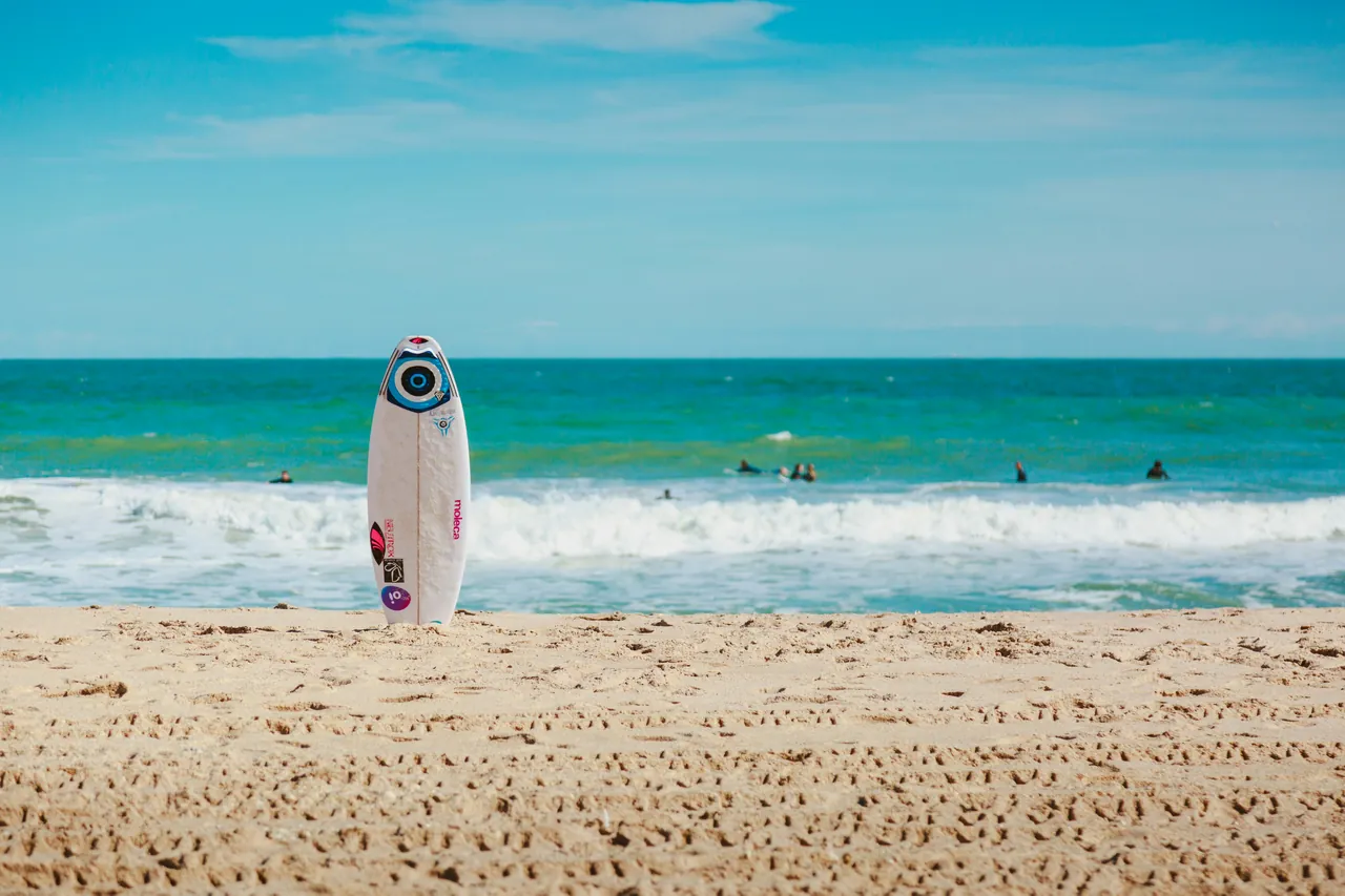 A surfing board standing in the sand. Photo by Lacie Slezak.